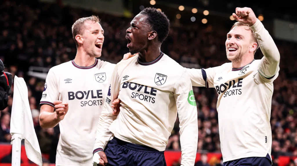 West Ham United players Tomas Soucek, Maxwel Cornet, and Jarrod Bowen celebrating a goal in their white away kit with Boyle Sports sponsor.